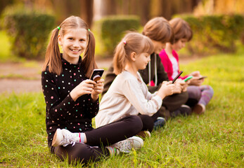 Distance learning online education. Caucasian smile kid girls studying with smartphone and doing school homework. Thinking child siting with cell phone. Back to school. 