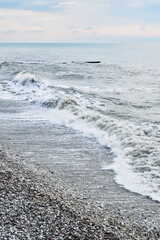 Beautiful sea landscape. Strong powerful sea waves break on shingle sea shore. Dangerous power of element of water.