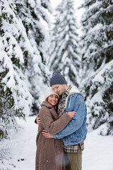 Fototapeta premium portrait of cute couple embracing in winter forest