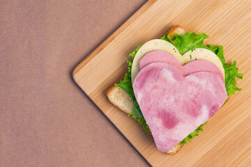 Heart shaped ham, sausage and cheese sandwich for breakfast with love