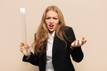 blonde woman looking angry, annoyed and frustrated screaming wtf or what’s wrong with you