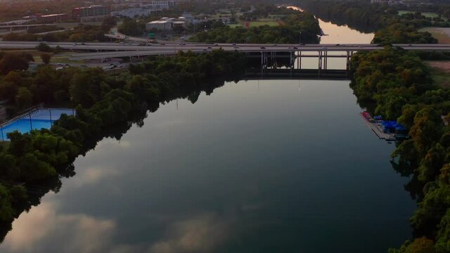 Austin's Lake Austin at Sunrise, as traffic crosses the river on Mopac with Downtown in the background.