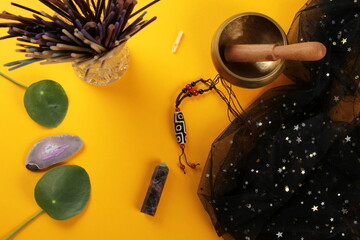 Tibetan dzi bead amulet necklace, tibetan singing bowl and other Success and prosperity symbols on a yellow background