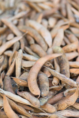Harvested ripe pods of kidney bean on heap. Pile of dry raw pods of haricot plant (Phaseolus vulgaris) as natural background. Organic farming, healthy food, BIO viands, back to nature concept.