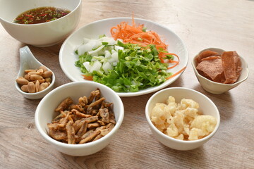 ingredient of crispy fish with pork couple maw topping peanut in spicy and sour chili sauce salad on plate