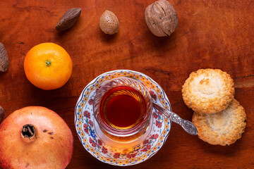 Top view of of traditional turkish tea with cookies , fruits and nuts .