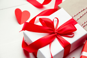 Valentines day gift box and red heart on white wooden background