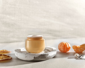 Beauty lifestyle background with Opened Jar of face cream and fresh tangerines.  winter skin care concept