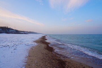 Baltic Sea coast in winter. Blue water, blue sky and snow on the shore.