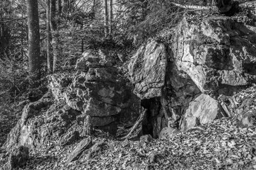 Schwarz weiß Bild Alte verwitterte Granit Felsen Formation mit Höhle und Durchbruch im Wald auf...