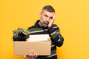 adult man feeling bored, frustrated and sleepy after a tiresome, dull and tedious task, holding...