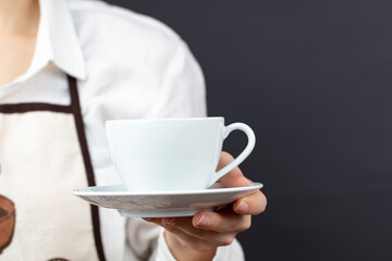 coffee time. A waiter holding and serving a glass of hot coffee isolated on a black background.
