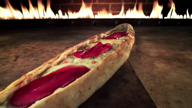 Turkish Traditional Baked Ramadan Food Pide. Turkish and Arabic Traditional Baked Ramadan Food Pide or Pizza ingredients with sliced halal lamb meat , butter, cheese and spicy herbs.In the oven.