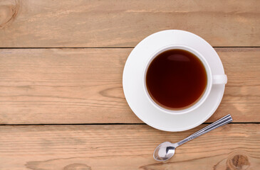 Top view of a teacup placed on an old wooden table in vintage style