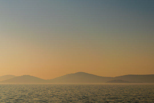 Hazy sunset seascape with sea horizon and clear sky, with mountain islands in the far end, Princes Islands, Sea of Marmara near Istanbul, natural photo background