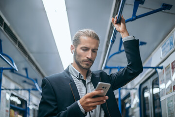 business man checking his email correspondence in the subway.