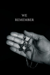 star of david in a pendant and text we remember