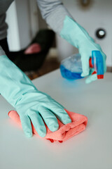 man wearing rubber gloves cleaning a table indoors