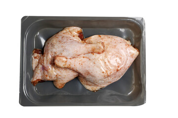 Two fresh uncooked duck legs on a grey plastic tray vacuumed packed. Poultry product. Isolated on white background.