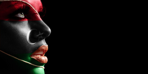 Libya flag painted on a face of a young woman, national flag