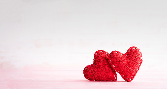 Two handmade red heart on bright wooden background. The symbol of love, couple and  Valentine's day concept