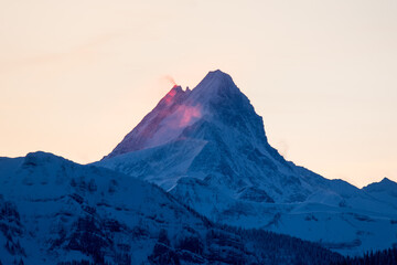 Naklejka premium peak of Schreckhorn at dawn with red clouds in winter