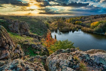 Beautiful small river among large stones and green vegetation on the hills in Ukraine