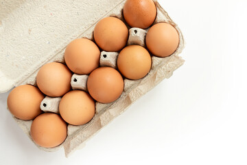 Chicken brown eggs in a tray, top view.