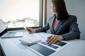 Fototapeta premium Businesswomen bookkeeper use smartphone and laptop doing account for paying tax on white desk in working office