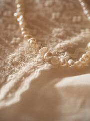 Delicate milky lace with a string of baroque pearls in the morning sun