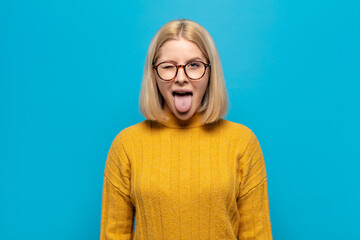 blonde woman with cheerful, carefree, rebellious attitude, joking and sticking tongue out, having...