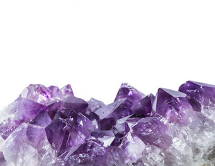 Close up view of large violet amethyst crystal cluster border isolated with white background....