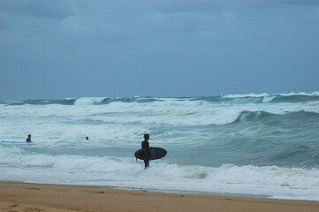 Fototapeta na wymiar surfer on the beach looking at the waves