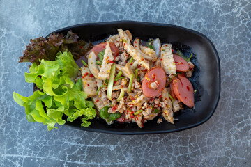 Yum hot dog and Vietnamese sausage in a black plate with beautiful greenery Thai food