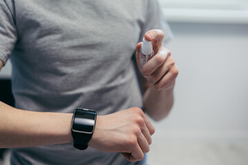 close up. casual young man using antibacterial spray.
