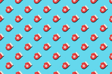 Christmas or New Year seamless pattern of red mitten with snowflake on blue background. Greeting card. Good for wallpaper, textile, background, poster, cover of book, post cards