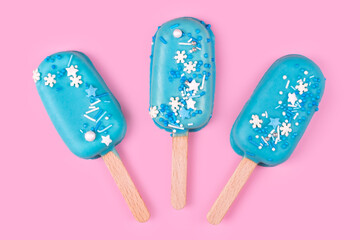 Blue mint ice cream popsicles on pastel pink background. Tasty and refreshing icecream on sticks. Minimal summer concept. Flat lay