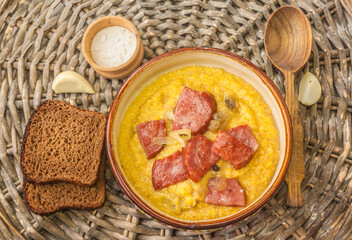 Banosh with sausages and onions, pieces of rye bread and garlic. Flat lay
