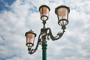 Fototapeta na wymiar Typical 3-headed lanterns against cloudy sky, Venice, Italy