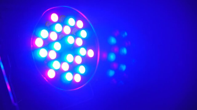 Closeup shot of multicolor projector spot lights on stage. Footage. Shot of searchlight shim with different colors. Party or disco equipment. Entertainment industry concept.