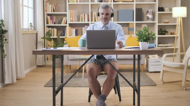 Businessman Wearing Jacket And Shirt And Underwear With No Pants Working From Home Having A Video Chat Conference Call,caucasian Mature Man Sitting At His Desk Has An Online Business Meeting 