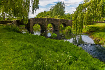 Fototapeta na wymiar A view along the bank towards the old Packhorse Bridge on the outskirts of Anstey, Leicestershire in summertime
