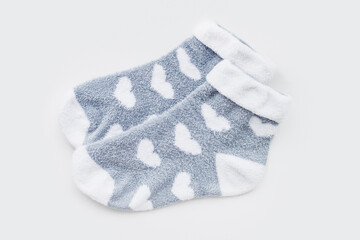 Pair of warm winter womens socks with print in the shape of hearts isolated on light gray background