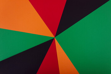 Red, yellow and green color paper on the black background. Black History Month concept. Flat lay....