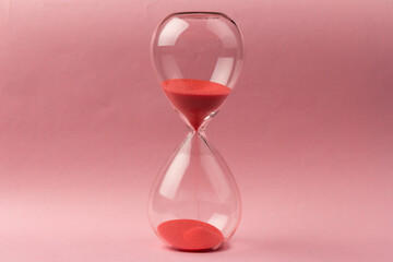 Crystal hourglass on pink background as a concept of passing time for business term, urgency and outcome of time.