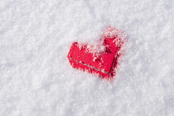 Red paper heart on fluffy snow. St Valentines day concept