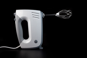 Side view on working hand mixer with stirring whisks rotate on high speed spin.
