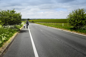 Happy father holding his little son?s hand and walking on road