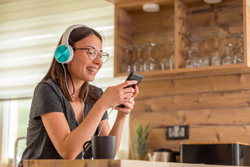 Woman wearing headset listening to the music at home