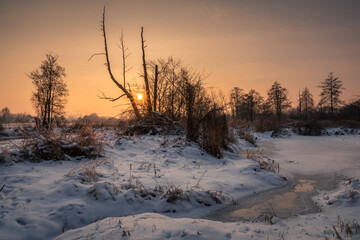 Sunset over the Jeziorka river at winter near Piaseczno, Masovia, Poland